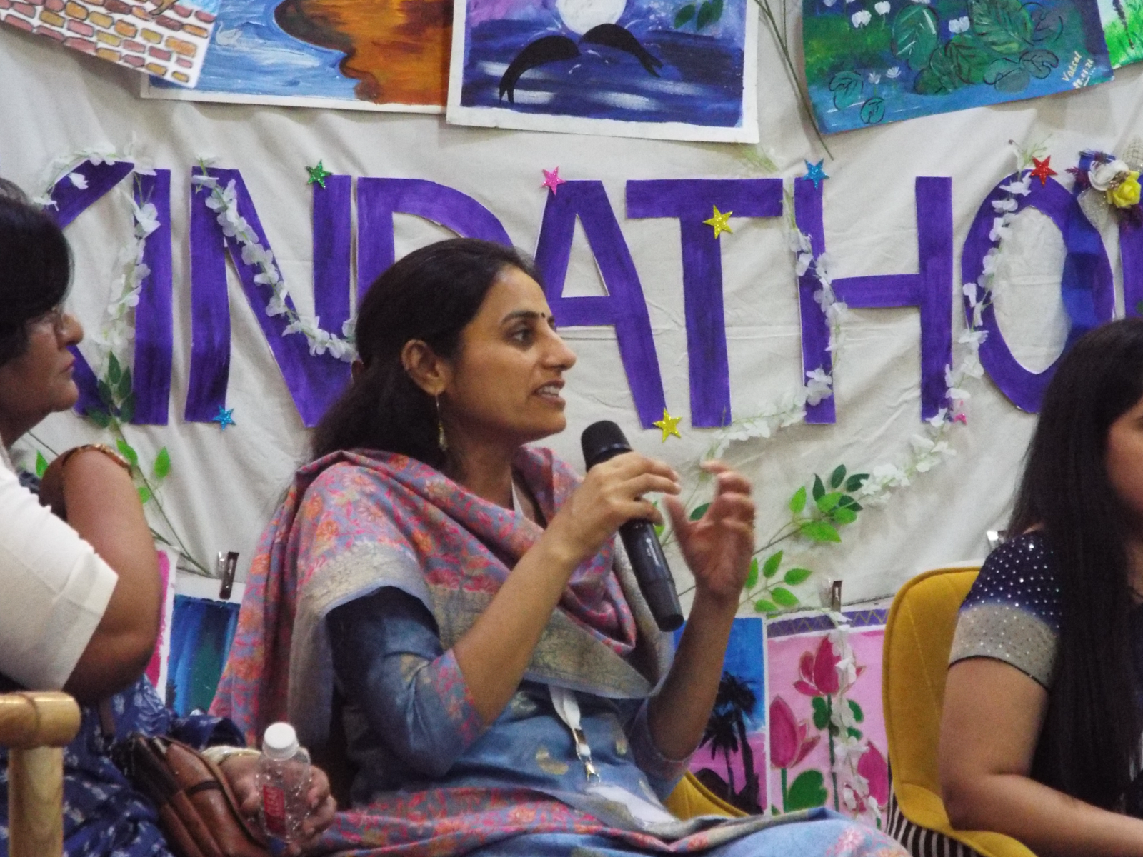 A speaker addressing the audience with a microphone during a panel conversation at a previous Kindathon event